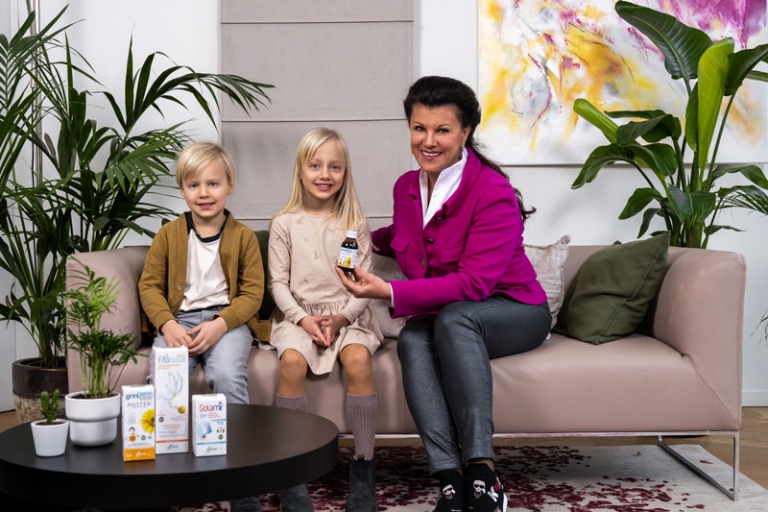 Aboca - neues Familienmitglied im Institut AllergoSan - Anita Frauwallner sitzt mit Kindern auf der Couch im Institut