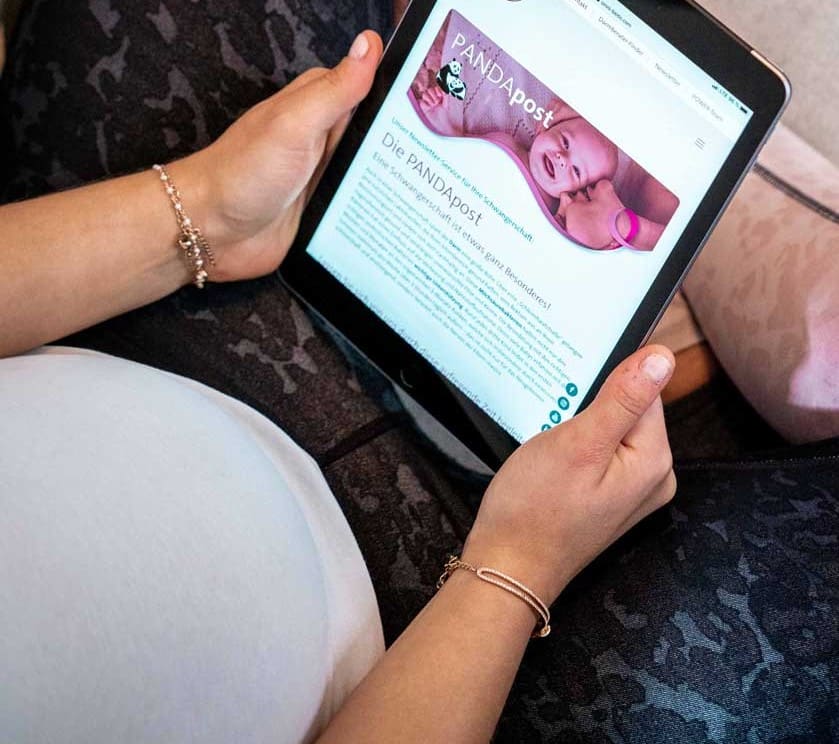 Schwanger Frau liest am Tablet die PANDApost